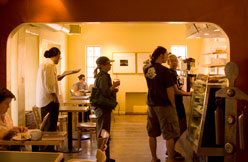 Customers at the counter inside the warmly lit cafe
